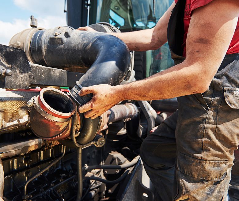 mężczyzna naprawiający maszynę rolniczą
